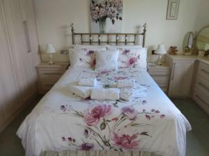 una camera da letto con un letto con fiori rosa di Coastal Garden Lodge a Preesall