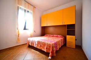 a bedroom with a bed and orange cabinets and a window at Piccolo Residence Gallipoli in Gallipoli