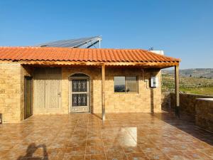 a brick house with a door and a patio at شقق الياسمين 2 in Jerash