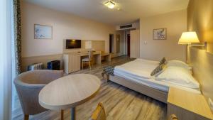 une chambre d'hôtel avec un lit et une table dans l'établissement Wellness Hotel Patince, à Patince