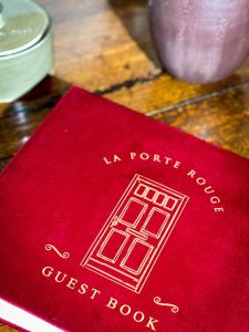een rood boek bovenop een tafel bij La Porte Rouge - The Red Door in Oudenaarde