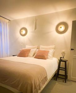 a bedroom with a large white bed with two pillows at La Porte Rouge - The Red Door in Oudenaarde
