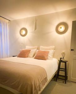 een slaapkamer met een groot wit bed met 2 kussens bij La Porte Rouge - The Red Door in Oudenaarde