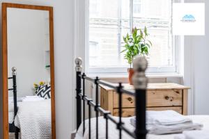 a bedroom with a bed and a window and a mirror at Charming 1 bed Apartment near Museum in London