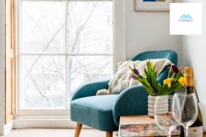 a blue couch in a living room with a window at Charming 1 bed Apartment near Museum in London