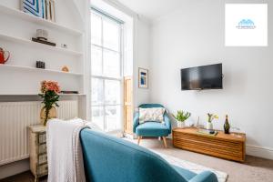 a living room with a blue chair and a tv at Charming 1 bed Apartment near Museum in London