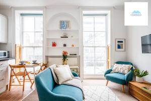 a living room with two blue chairs and a table at Charming 1 bed Apartment near Museum in London