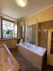 a large bathroom with a tub and a window at Gioco in San Vincenzo
