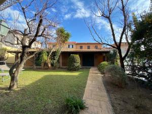 a house with a yard with trees and a pathway at Gioco in San Vincenzo