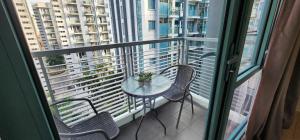 a table and chairs on a balcony with a window at palm tree villas in Manila