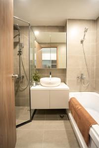 胡志明市的住宿－SQ Thao Dien，浴室配有水槽、淋浴和浴缸。