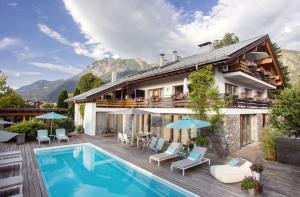 a villa with a swimming pool and a house at Bergesgrün in Oberstdorf
