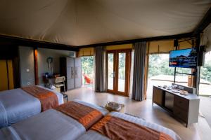 a bedroom with two beds and a flat screen tv at JSI Resort in Puncak