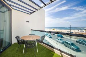 a balcony with a table and chairs and a view of the ocean at Casa Corralito - 2 bed apartment with sea and sunset views in Cotillo
