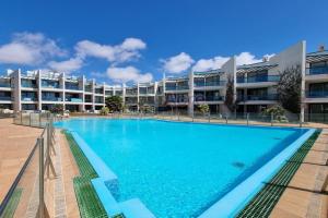 a large swimming pool in front of a building at Casa Corralito - 2 bedrooms, rooftop sea view in Cotillo