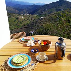 a table with plates of food on a table with a view at Casa Junius in Arenas