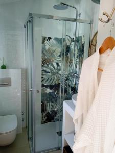 um chuveiro com uma porta de vidro na casa de banho em Casa Junius em Arenas