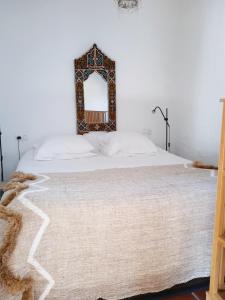 um quarto com uma cama com um espelho na parede em Casa Junius em Arenas