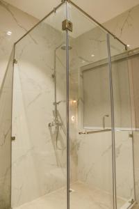 y baño con ducha y puerta de cristal. en Noune Resort, en Dimāpur