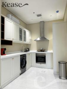 cocina con armarios blancos y lavadora en Kease Hittin K-9 Latest Development Balcony GX53, en Riad