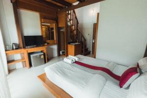 1 dormitorio con 1 cama grande y TV en Lanta Ray Bay Hotel en Ko Lanta