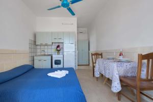 una cucina con letto blu e tavolo da pranzo di Residence La Scogliera by BarbarHouse a Torre Colimena