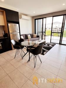 een woonkamer met een tafel en stoelen en een bank bij Stylish, Modern, Cute as a Button - Braddon CBD in Canberra