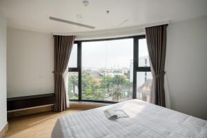 sypialnia z łóżkiem i dużym oknem w obiekcie SQ Thao Dien w Ho Chi Minh