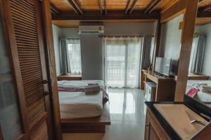 Habitación pequeña con 2 camas y TV. en Lanta Ray Bay Hotel en Ko Lanta