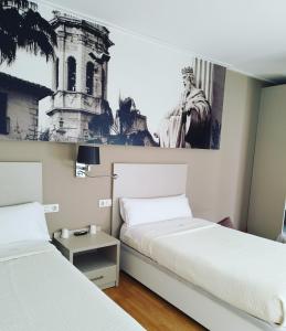 a bedroom with two beds and a picture on the wall at Hello Villarreal Suites in Villareal