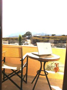 un computer portatile seduto su un tavolo sul balcone di Emmanouela Studios & Villas a Karterados