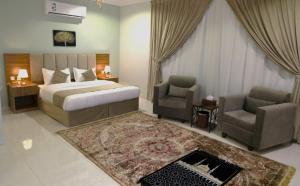 1 dormitorio con 1 cama, 2 sillas y sofá en وردة رومه للوحدات السكنية en Medina