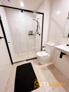 een badkamer met een douche, een toilet en een wastafel bij Stylish, Modern, Cute as a Button - Braddon CBD in Canberra