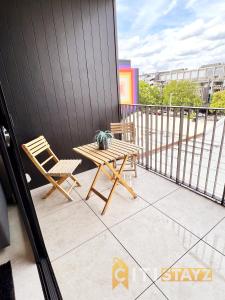 een patio met een tafel en stoelen op een balkon bij Stylish, Modern, Cute as a Button - Braddon CBD in Canberra