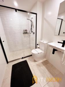 een badkamer met een douche, een toilet en een wastafel bij Stylish, Modern, Cute as a Button - Braddon CBD in Canberra