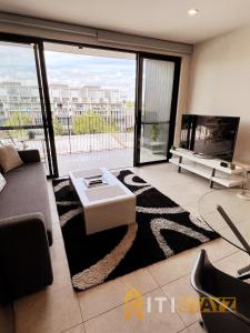 a living room with a couch and a tv at Stylish, Modern, Cute as a Button - Braddon CBD in Canberra
