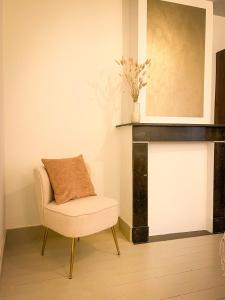 a chair with a pillow on it in a room at La Porte Rouge - The Red Door in Oudenaarde +18 photos