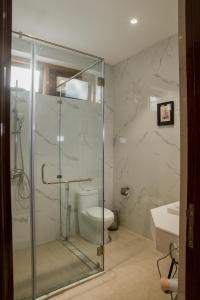 y baño con ducha, aseo y lavamanos. en Noune Resort, en Dimāpur