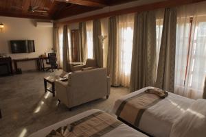 Habitación de hotel con cama y silla en Noune Resort, en Dimāpur