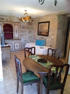 uma sala de jantar com uma mesa e uma cozinha em Casa da Massada em Belmonte