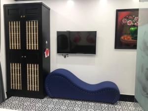 a blue bench in a room with a tv at Song Kim Hotel in Hai Phong