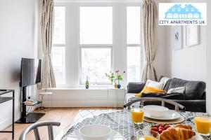 una sala de estar con una mesa con comida. en Charming 1 Bed Apt in Kensington - Free London Tour Included By City Apartments UK Short Lets Serviced Accommodation, en Londres