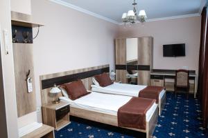 a hotel room with two beds and a desk at Nurtau in Pavlodar
