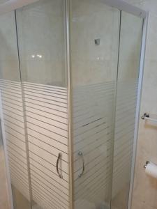 y baño con ducha y puerta de cristal. en Casa da Massada, en Belmonte