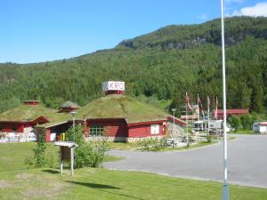 un edificio con techo de hierba con un cartel. en Nordnes Kro og Camping, en Rokland