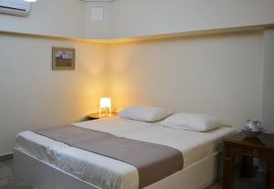 1 dormitorio con 1 cama con lámpara. en Kalamata beach maizonette ground floor and semi-basement with yard, en Kalamata