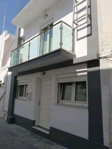 a white building with a balcony and a door at Sunrise in Kardamaina