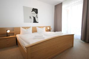 ein Schlafzimmer mit einem großen Bett mit weißer Bettwäsche in der Unterkunft Haus Anna by Rujana in Binz