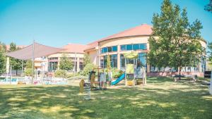 a school building with a playground in the yard at Wellness Hotel Patince in Patince