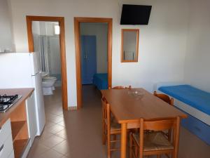 eine Küche und ein Esszimmer mit einem Tisch und einem Kühlschrank in der Unterkunft Villaggio Bellariva in Peschici
